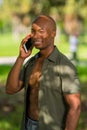 Portrait happy African American man talking on the phone outdoors in a park setting Royalty Free Stock Photo