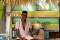 Portrait of happy african american man using tablet sitting behind counter of surf hire beach shack Royalty Free Stock Photo