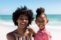 Portrait of happy african american mother and daughter enjoying sunny day at beach Royalty Free Stock Photo