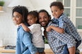 Portrait happy African American parents piggy backing two kids Royalty Free Stock Photo