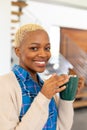 Portrait of happy african american woman holding mug, looking at camera and smiling Royalty Free Stock Photo