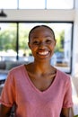 Portrait of happy african american woman looking at camera and smiling in sunny living room Royalty Free Stock Photo