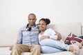 Portrait of happy African American young couple relaxing on sofa Royalty Free Stock Photo