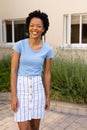 Portrait of happy african american young woman smiling while standing outdoors Royalty Free Stock Photo