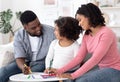 Portrait of happy african family with little daughter drawing together at home Royalty Free Stock Photo