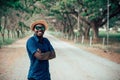 Portrait of the happy african man in sunglasses standing on the dirt road, smiling and looking at the camera Royalty Free Stock Photo