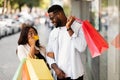 Portrait of happy afro woman showing credit card to man Royalty Free Stock Photo