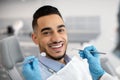 Portrait Of Happy Arab Man Sitting At Dentist Chair In Modern Clinic Royalty Free Stock Photo