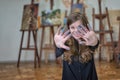 Portrait of happy artist in the art studio shows her dirty hands stained with paints. Royalty Free Stock Photo