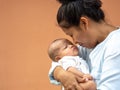 Portrait of happy Asia mother holding his newborn sweet baby dressed. The mommy embracing her baby with love and care. her daughte Royalty Free Stock Photo