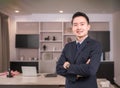 Portrait of happy Asian businessman CEO in suit with arms crossed and looking at camera in modern room at workplace Royalty Free Stock Photo