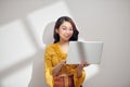 Portrait of a happy asian businesswoman holding laptop computer and looking away solated over white background Royalty Free Stock Photo