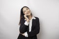 A portrait of a happy Asian businesswoman is smiling while talking on phone call wearing a black suit isolated by a white Royalty Free Stock Photo