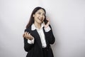 A portrait of a happy Asian businesswoman is smiling while talking on phone call wearing a black suit isolated by a white Royalty Free Stock Photo