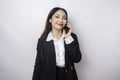 A portrait of a happy Asian businesswoman is smiling while talking on phone call wearing a black suit isolated by a white Royalty Free Stock Photo