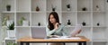 Portrait of businesswoman using laptop computer while working with using a calculator to calculate the numbers, finance Royalty Free Stock Photo