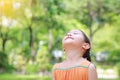 Portrait of happy Asian child close their eyes in garden with Breathe fresh air from nature. Close up kid girl relax in green park Royalty Free Stock Photo