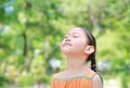 Portrait of happy Asian child close their eyes in garden with Breathe fresh air from nature. Close up kid girl relax in green park Royalty Free Stock Photo