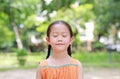 Portrait of happy Asian child close their eyes in garden with Breathe fresh air from nature. Close up kid girl relax in green park Royalty Free Stock Photo