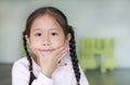 Portrait of Happy asian child girl showing her nails with fashion jewels