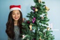 Portrait of happy Asian Chinese girl with Santa Claus hat celebrate Christmas near xmas tree to enjoy 2018 holiday and 2019 new