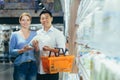 Portrait of a happy asian couple of consumers, supermarket shoppers or grocery store looking at camera smiling. Glad Royalty Free Stock Photo