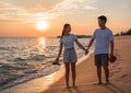 Portrait of happy Asian couple hands holding and walking smile together on beach while golden sunset time evening Royalty Free Stock Photo