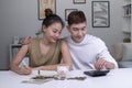 Portrait of a happy Asian couple at home saving money in a piggybank.Woman and man couple at home saving money in a piggybank. Royalty Free Stock Photo