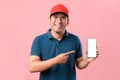 Portrait of Happy Asian delivery man showing phone screen and pointing at phone screen Royalty Free Stock Photo