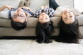 Portrait Happy Asian Family hanging upside down on sofa in living room. Royalty Free Stock Photo