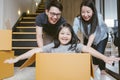 Portrait of happy Asian family moving to new house with cardboard boxes. Royalty Free Stock Photo