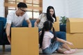 Portrait of happy Asian family moving to new house with cardboard boxes and playing cardboard box. Royalty Free Stock Photo