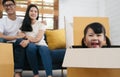 Portrait of happy Asian family moving to new house with cardboard boxes and playing cardboard box. Royalty Free Stock Photo