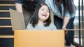 Portrait of happy Asian family moving to new house with cardboard boxes and playing cardboard box. Royalty Free Stock Photo