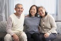 portrait happy asian family,older adult father and mother with young adult daughter sitting on couch Royalty Free Stock Photo