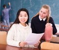 Happy asian female student reading notification with girl friend