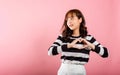 Portrait of a happy Asian lady with a confident smile, making a heart symbol with her fingers and Royalty Free Stock Photo