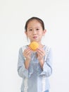 Portrait of happy asian little child girl hold and eating Custard Cake isolated on white background