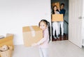Portrait of a happy asian little daughter carrying boxes into the a new home on moving day. Happy Family move on a new home Royalty Free Stock Photo