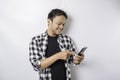 A portrait of a happy Asian man is smiling while holding on his phone, isolated by white background Royalty Free Stock Photo