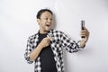 A portrait of a happy Asian man is smiling while holding on his phone, isolated by white background Royalty Free Stock Photo