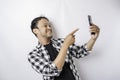 A portrait of a happy Asian man is smiling while holding on his phone, isolated by white background Royalty Free Stock Photo