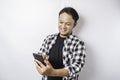 A portrait of a happy Asian man is smiling while holding on his phone, isolated by white background Royalty Free Stock Photo