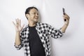 A portrait of a happy Asian man is smiling while holding on his phone, isolated by white background Royalty Free Stock Photo