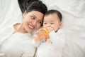 Portrait of happy asian mother and baby having fun together at home in white room Royalty Free Stock Photo