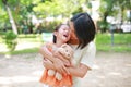 Portrait of happy Asian mother cuddle daughter and hugging teddy bear doll in the garden. Mom and child girl with love and Royalty Free Stock Photo