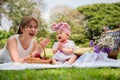 Portrait of happy Asian mother and her cute little daughter good mood smiling and playing having fun together while picnic in a Royalty Free Stock Photo