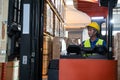 Portrait of happy Asian old man working in warehouse and sitting on forklift work with positive emotion.