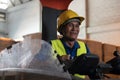 Portrait of happy Asian old man working in warehouse and sitting on forklift work with positive emotion.