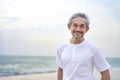 portrait happy asian senior man travel in nature,smiling and standing on the beach on summer time, Royalty Free Stock Photo